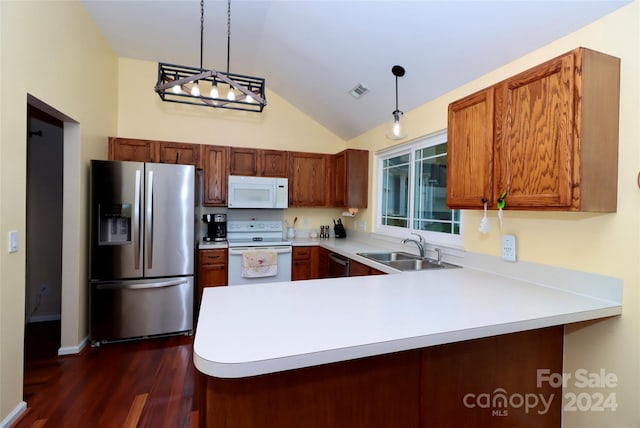 kitchen with appliances with stainless steel finishes, dark hardwood / wood-style floors, hanging light fixtures, sink, and kitchen peninsula