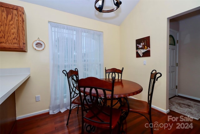 dining space featuring dark hardwood / wood-style floors, a chandelier, and vaulted ceiling