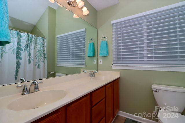 bathroom featuring toilet, vanity, and a shower with shower curtain