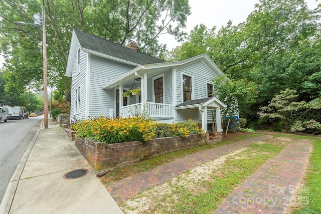 view of front of house featuring covered porch and a chimney