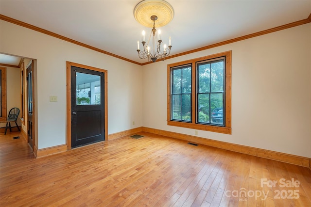 interior space with a chandelier, a healthy amount of sunlight, visible vents, and wood finished floors