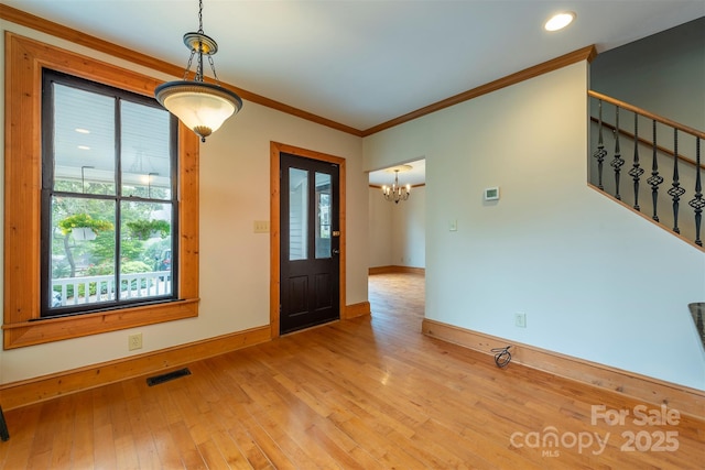 entrance foyer with baseboards, visible vents, stairway, crown molding, and light wood-type flooring