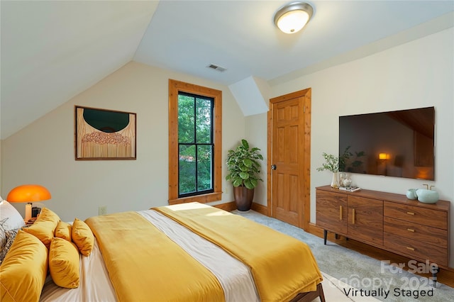 bedroom featuring vaulted ceiling, carpet flooring, and visible vents