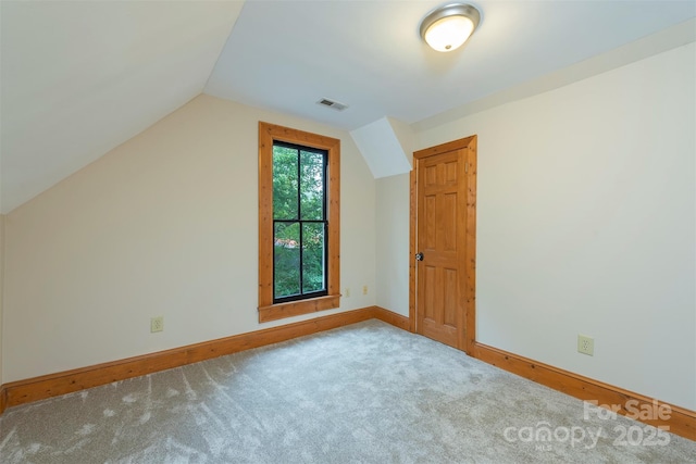 additional living space featuring carpet, visible vents, vaulted ceiling, and baseboards