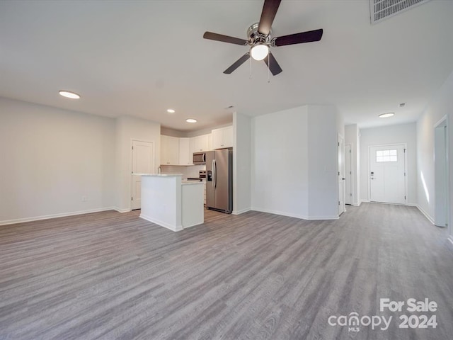 unfurnished living room with light wood-type flooring and ceiling fan