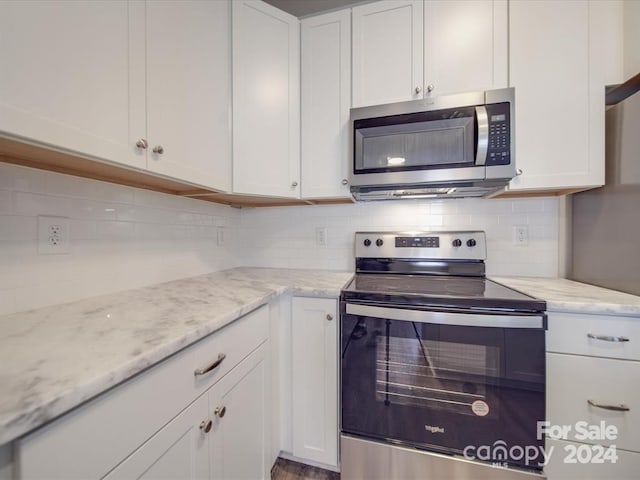 kitchen featuring appliances with stainless steel finishes, light stone counters, backsplash, and white cabinets