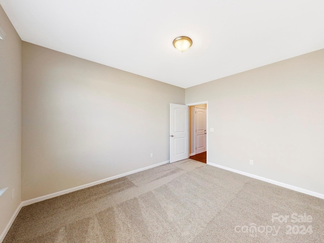 empty room with carpet and baseboards