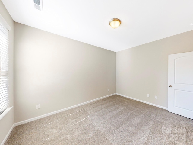 unfurnished room with carpet floors, baseboards, and visible vents