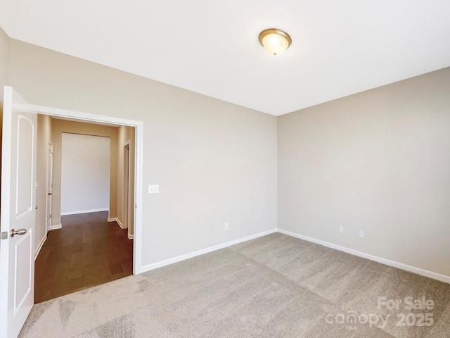 unfurnished room featuring carpet and baseboards