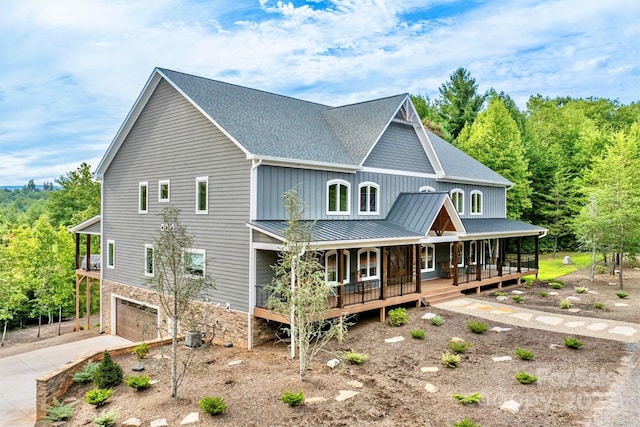 view of front of home with cooling unit, covered porch, and a garage