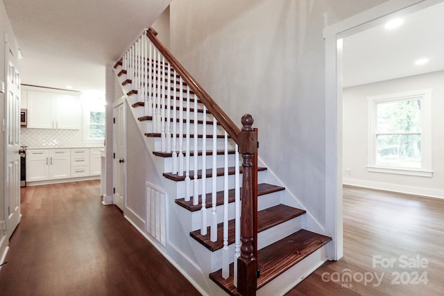 stairs featuring hardwood / wood-style floors