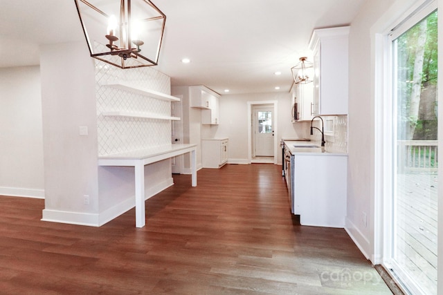 kitchen featuring white cabinetry, a notable chandelier, sink, dark wood-type flooring, and tasteful backsplash