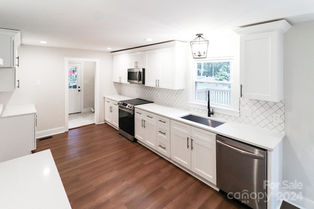 kitchen featuring white cabinetry, sink, decorative backsplash, dark hardwood / wood-style floors, and appliances with stainless steel finishes