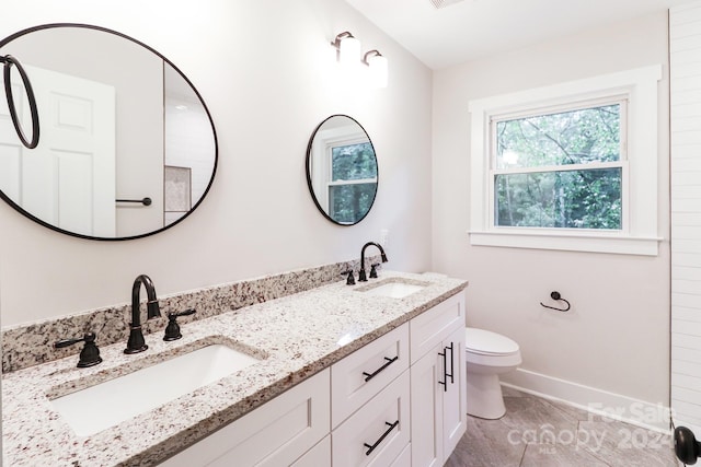 bathroom featuring tile patterned flooring, toilet, and vanity