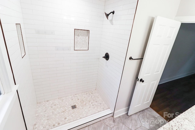 bathroom featuring tiled shower and hardwood / wood-style floors