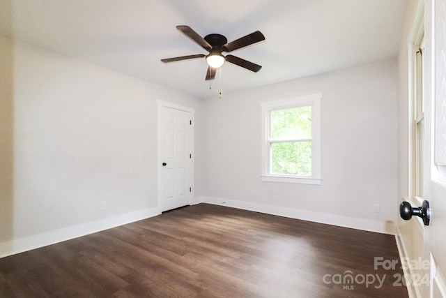 unfurnished room featuring dark wood-type flooring and ceiling fan