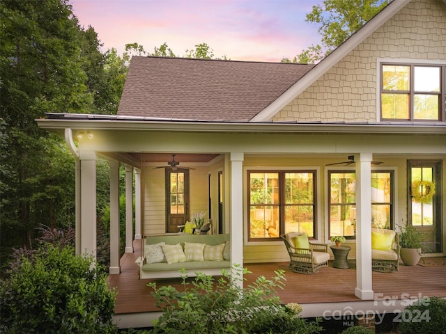 back house at dusk with an outdoor living space and ceiling fan