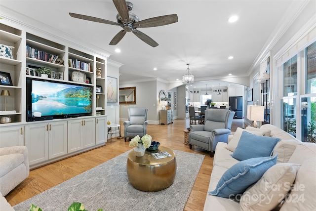 living room featuring ceiling fan with notable chandelier, ornamental molding, and light hardwood / wood-style flooring