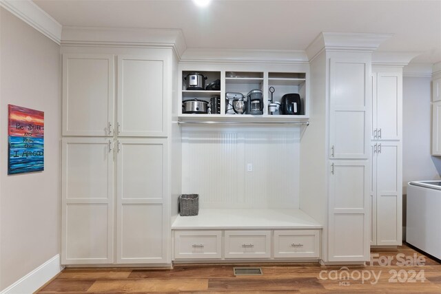 mudroom with crown molding, washer / dryer, and light wood-type flooring