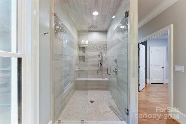 bathroom featuring walk in shower, ornamental molding, and hardwood / wood-style flooring