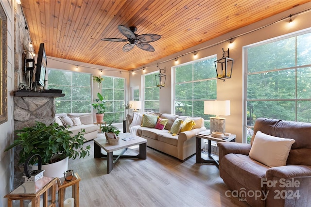 sunroom / solarium featuring wood ceiling, a healthy amount of sunlight, and ceiling fan