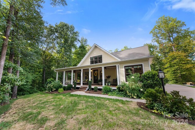 view of front of house with a front yard and a porch