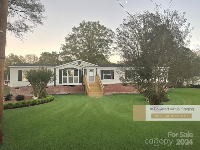 back house at dusk with a lawn