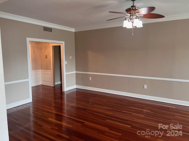 spare room with dark wood-type flooring, ceiling fan, and ornamental molding