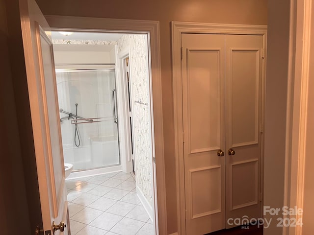 bathroom with tile patterned floors, a shower stall, and toilet