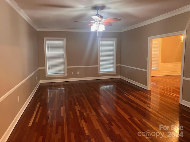 spare room with ceiling fan, crown molding, baseboards, and wood finished floors