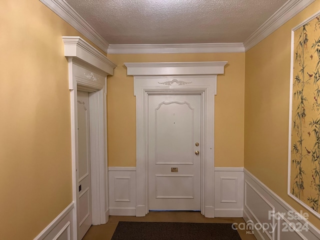 doorway with a textured ceiling and ornamental molding