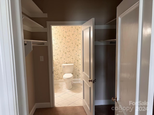 bathroom with wallpapered walls, tile patterned floors, toilet, and baseboards