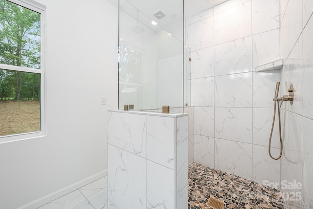 bathroom featuring plenty of natural light and tiled shower