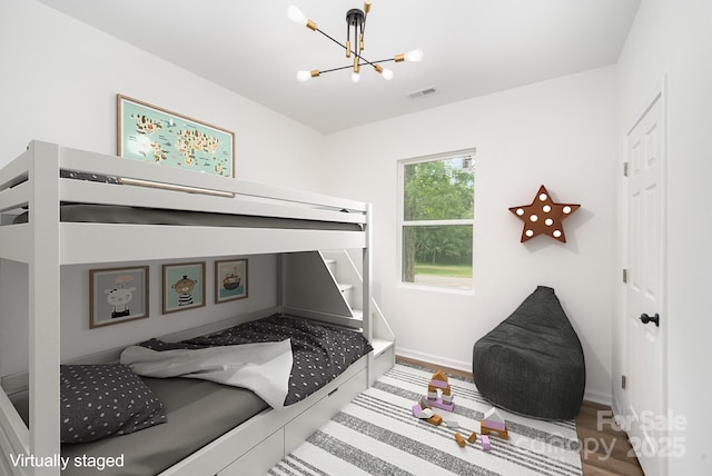 bedroom featuring hardwood / wood-style floors and an inviting chandelier