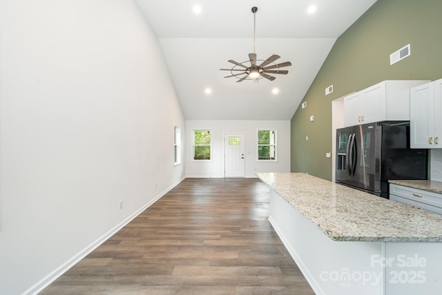 kitchen featuring white cabinets, hardwood / wood-style flooring, ceiling fan, light stone countertops, and stainless steel fridge with ice dispenser