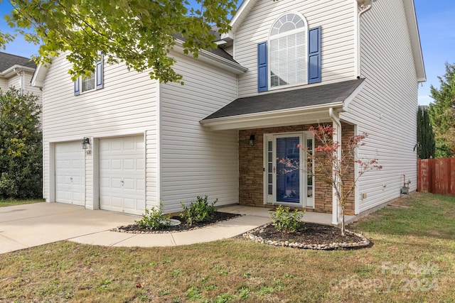 front facade featuring a garage and a front lawn