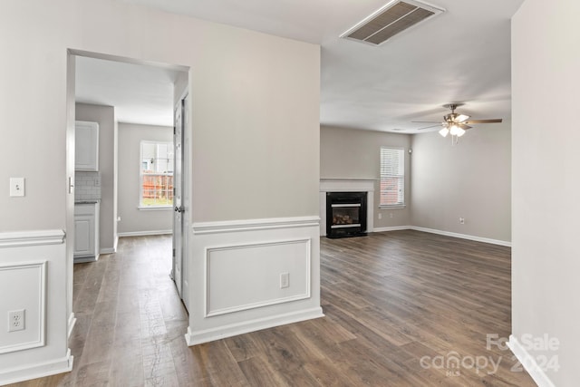 interior space with a fireplace, dark wood-type flooring, and ceiling fan