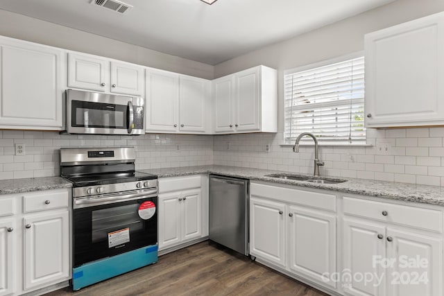 kitchen with white cabinets, sink, backsplash, stainless steel appliances, and dark hardwood / wood-style flooring