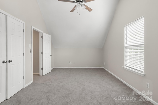 additional living space featuring ceiling fan, light colored carpet, and lofted ceiling