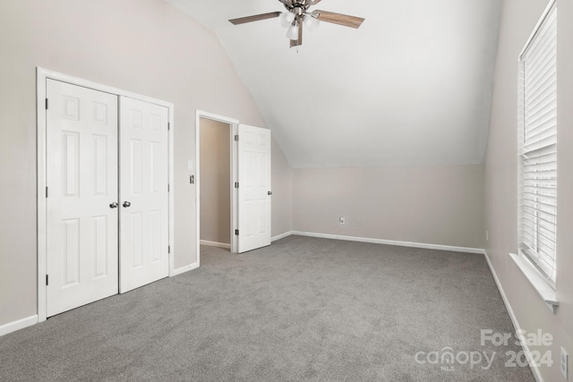 unfurnished bedroom with a closet, vaulted ceiling, ceiling fan, and carpet floors