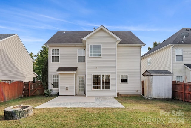 back of property with a yard, a storage unit, an outdoor fire pit, and a patio area