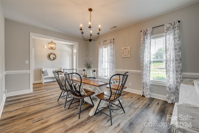 dining area with hardwood / wood-style flooring and a chandelier