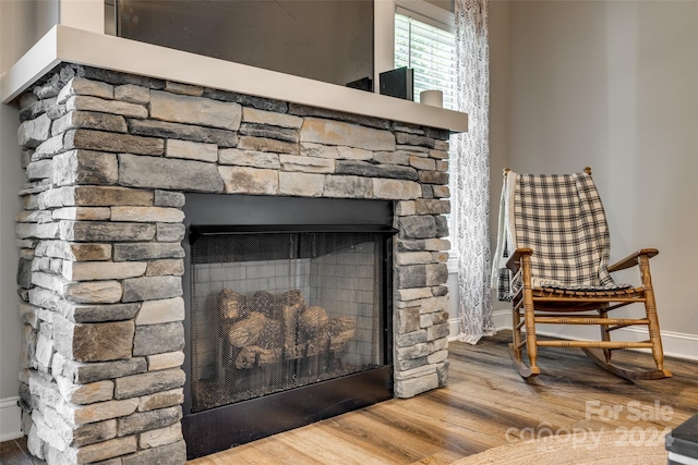 room details featuring hardwood / wood-style floors and a stone fireplace