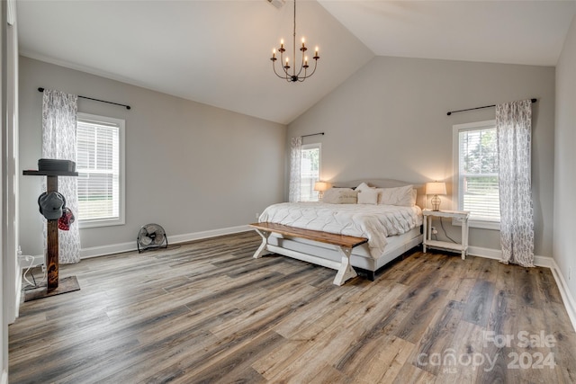 bedroom with a notable chandelier, hardwood / wood-style floors, and multiple windows