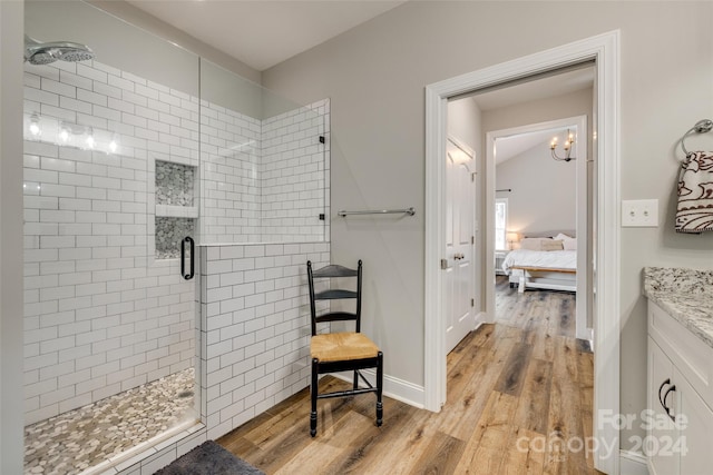 bathroom with wood-type flooring, an enclosed shower, and vanity