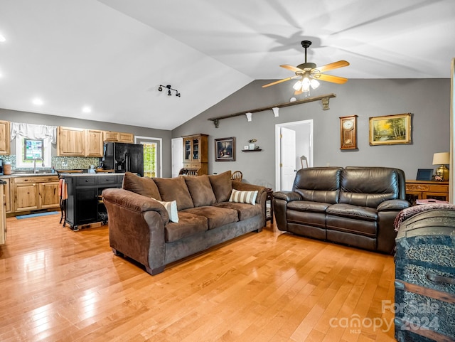 living room featuring ceiling fan, a wealth of natural light, vaulted ceiling, and light hardwood / wood-style flooring