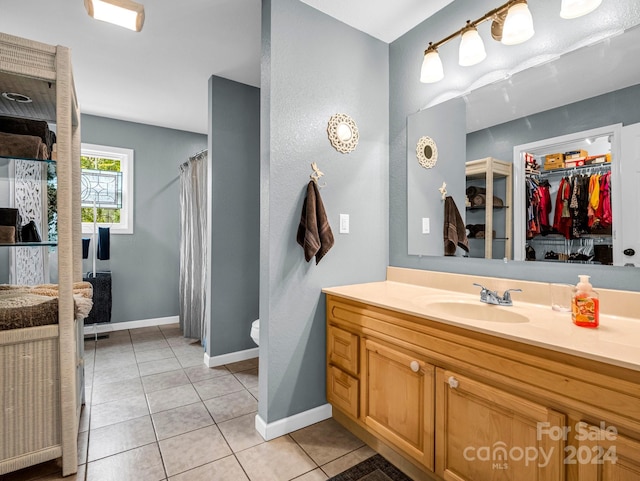 bathroom featuring tile patterned flooring, vanity, and toilet