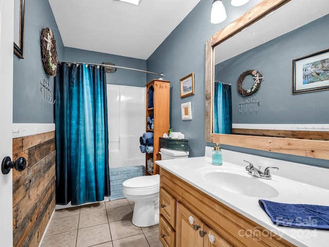 bathroom featuring tile patterned flooring, vanity, toilet, and walk in shower