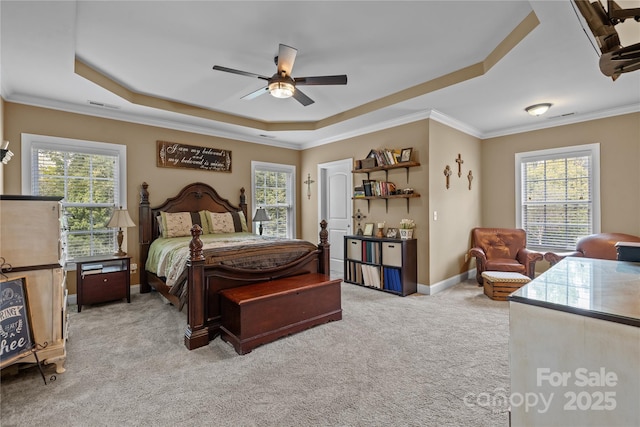 carpeted bedroom featuring a tray ceiling, ornamental molding, and ceiling fan