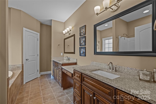 bathroom with tile patterned floors, vanity, and tiled tub